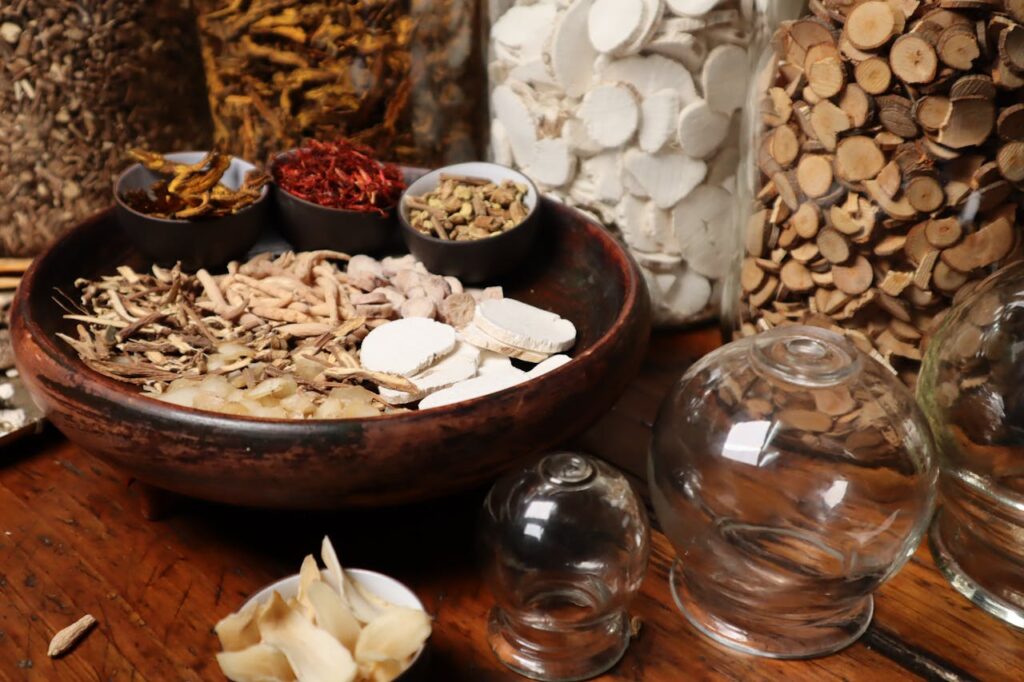 A collection of dried herbs and ingredients used in traditional medicine, displayed in a rustic setting.